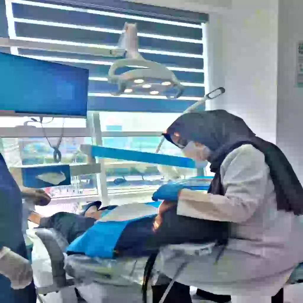 Dr. Zohreh Ahrahi giving dental treatment to the patient in the back ground of ferdows medical center