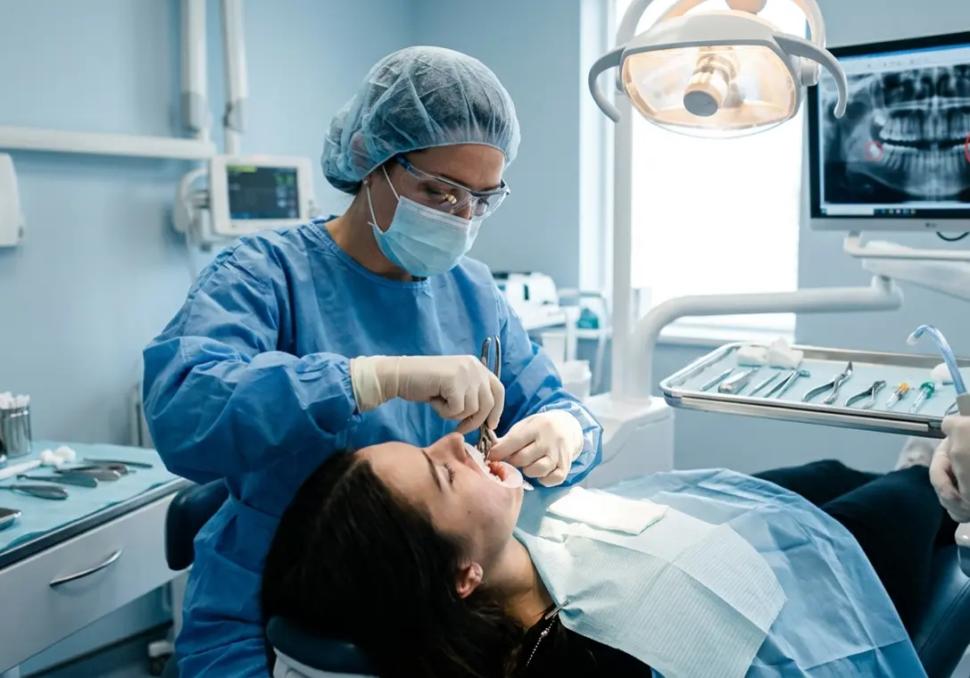 Doctor in a procedure for wisdom tooth extraction for a patient in background of operation theator